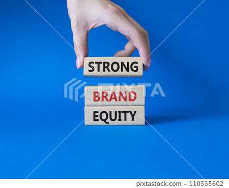 Strong Brand Equity symbol. Concept words Strong Brand Equity on wooden blocks. Businessman hand. Beautiful blue background. Business and Strong Brand Equity concept. Copy space 110535602