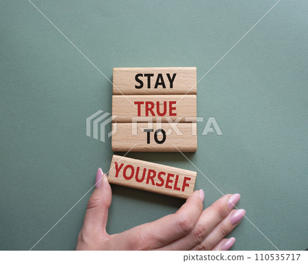 Stay True to Yourself symbol. Wooden blocks with words Stay True to Yourself. Businessman hand. Beautiful grey green background. Business and Stay True to Yourself concept. Copy space. Stay True to Yourself symbol. Wooden blocks with words Stay True to Yourself. Businessman hand. Beautiful grey green background. Business and Stay True to Yourself concept. Copy space. 110535717