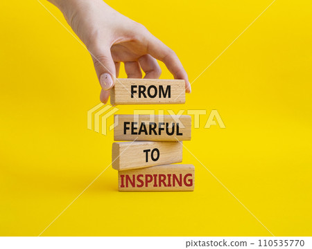 From Fearful to Inspiring symbol. Concept words From Fearful to Inspiring on wooden blocks. Businessman hand. Beautiful yellow background. Business and From Fearful to Inspiring concept. Copy space. 110535770