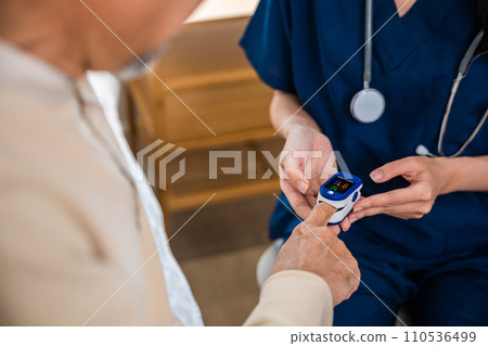 Young woman putting digital oximeter of finger middle aged adult patient for measurement, nurse checking with fingertip pulse oximeter oxygen meter blood monitor finger of senior old man at hospital Young woman putting digital oximeter of finger middle aged adult patient for measurement, nurse checking with fingertip pulse oximeter oxygen meter blood monitor finger of senior old man at hospital 110536499