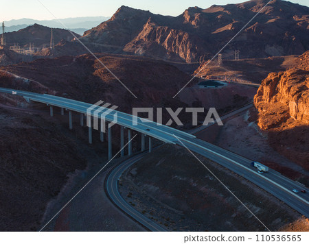 Hoover Dam on the Colorado River straddling Nevada and Arizona at dawn from above. Aerial view of Hoover Dam and the Colorado River Bridge 110536565