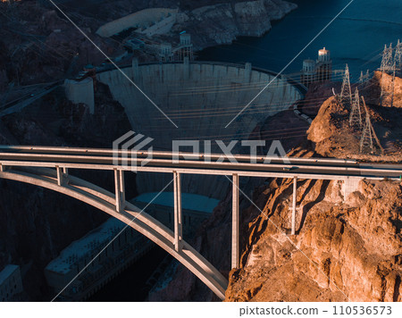 Hoover Dam on the Colorado River straddling Nevada and Arizona at dawn from above. Aerial view of Hoover Dam and the Colorado River Bridge Hoover Dam on the Colorado River straddling Nevada and Arizona at dawn from above. Aerial view of Hoover Dam and the Colorado River Bridge 110536573
