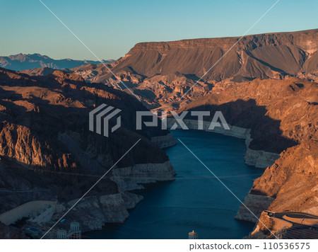 Hoover Dam on the Colorado River straddling Nevada and Arizona at dawn from above. Aerial view of Hoover Dam and the Colorado River Bridge Hoover Dam on the Colorado River straddling Nevada and Arizona at dawn from above. Aerial view of Hoover Dam and the Colorado River Bridge 110536575