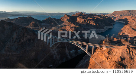 Hoover Dam on the Colorado River straddling Nevada and Arizona at dawn from above. Aerial view of Hoover Dam and the Colorado River Bridge 110536659