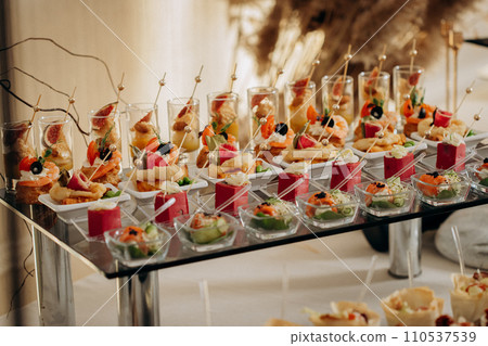 Assortment of delicious snacks on the open buffet festive table in restaurant. Catering plate Assortment of delicious snacks on the open buffet festive table in restaurant. Catering plate 110537539