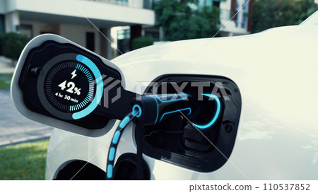 EV charger from home charging station recharging electric car. Peruse EV charger from home charging station recharging electric car. Peruse 110537852