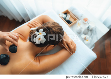 Hot stone massage at spa salon in luxury resort. Quiescent 110537874