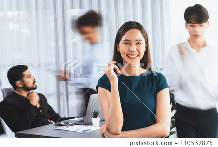 Young Asian businesswoman poses confidently in busy meeting room. Concord 110537875