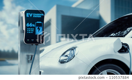 Electric car recharge to charging station with future building. Peruse 110537884