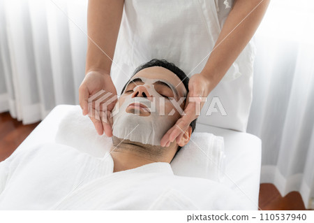 Woman customer indulges in rejuvenating with facial skincare mask. Quiescent 110537940