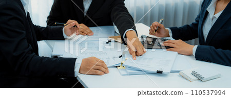 Corporate accountant team use calculator to calculate financial report. Shrewd 110537994