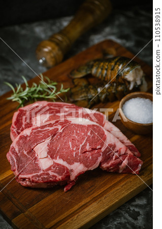 fresh ribeye steak and lobster tail on black marble background fresh ribeye steak and lobster tail on black marble background 110538915