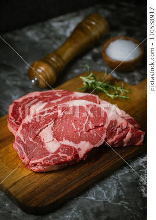 raw ribeye steak meat on black marble background raw ribeye steak meat on black marble background 110538917