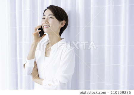 Middle-aged woman talking on smartphone Middle-aged woman talking on smartphone 110539286