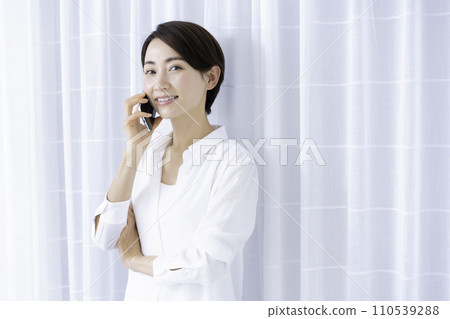 Middle-aged woman talking on smartphone Middle-aged woman talking on smartphone 110539288