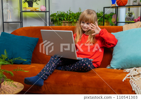 Preteen child girl looking at laptop camera, making video webcam conference call with friends family Preteen child girl looking at laptop camera, making video webcam conference call with friends family 110541303