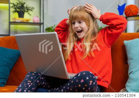 Amazed teen girl use laptop computer, receive good news message, shocked by victory, celebrate win Amazed teen girl use laptop computer, receive good news message, shocked by victory, celebrate win 110541304