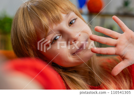 Child kid girl taking selfie on smartphone communicating video call home online with subscribers 110541305