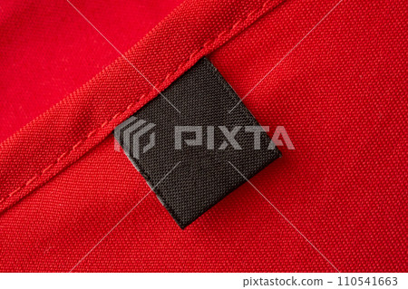 Blank black laundry care clothes label on red fabric texture background 110541663