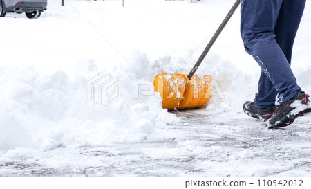 Man shoveling snow off of his driveway after a winter storm in Canada. Man with snow shovel cleans sidewalks in winter. Winter time. Man shoveling snow off of his driveway after a winter storm in Canada. Man with snow shovel cleans sidewalks in winter. Winter time. 110542012