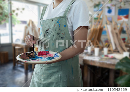 young man holding painter palette at artist studio. artist concept 110542369