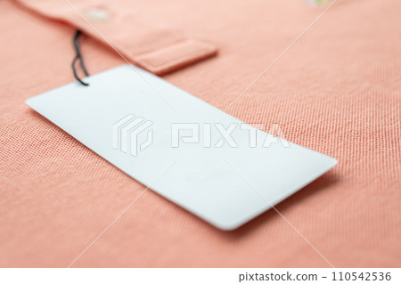 Blank white clothes tag label on pink fabric texture background Blank white clothes tag label on pink fabric texture background 110542536