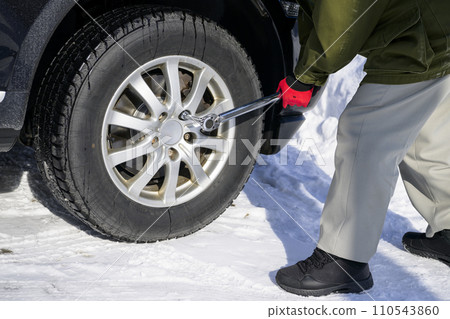 一個人用扭力扳手擰緊輪胎螺母 110543860