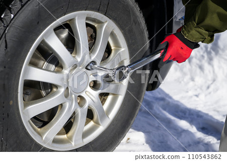 A man tightens a tire nut with a torque wrench 110543862