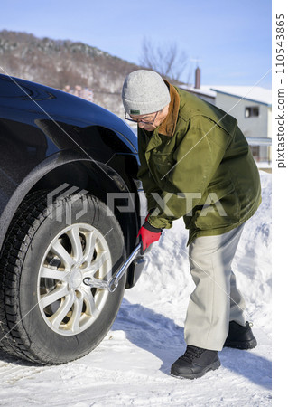 A man tightens a tire nut with a torque wrench 110543865