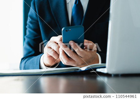 Hand of a businessman sending an email with a smartphone Hand of a businessman sending an email with a smartphone 110544961
