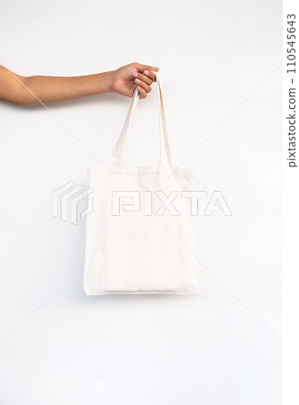Females hand holding reusable textile shopping bag. Females hand holding reusable textile shopping bag. 110545643