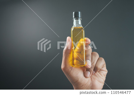 hand holding a bottle of olive oil hand holding a bottle of olive oil 110546477