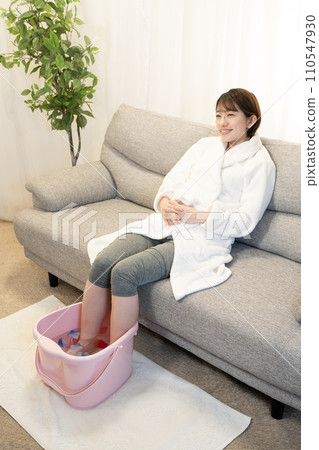 A woman smiling while taking a footbath 110547930