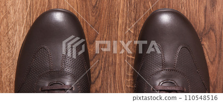 Brown shoes for men on rustic board, male footwear concept 110548516