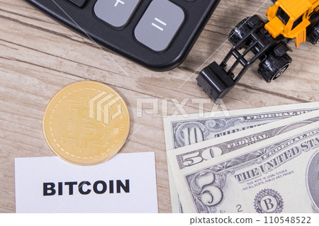 Bitcoin, dollar bills, miniature excavator and calculator. Cryptocurrency Bitcoin, dollar bills, miniature excavator and calculator. Cryptocurrency 110548522
