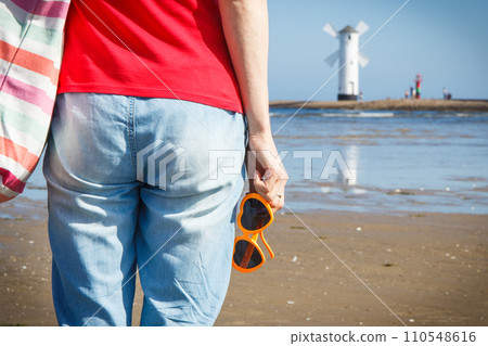 Woman with sunglasses in shape of heart on west breakwater. Windmill Stawa Mlyny in Swinoujscie. 110548616