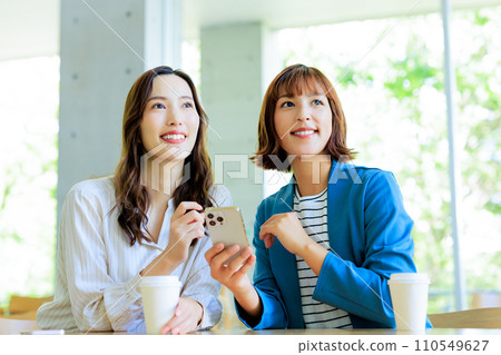 一個女人在一家咖啡館看智能手機 110549627