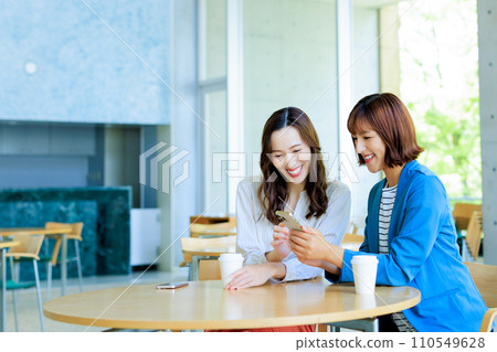 一個女人在一家咖啡館看智能手機 110549628