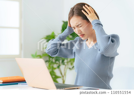 一個女人一邊看電腦一邊擔心 110551554