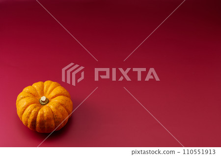 頭頂拍攝的紫色背景，左下角放置一個小南瓜 110551913