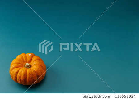 俯視拍攝,背景為藍色,中間有一個小南瓜,左下角有一個 俯視拍攝,背景為藍色,中間有一個小南瓜,左下角有一個 110551924