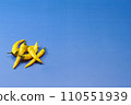 藍色背景的頭頂拍攝，左下角放置多個黃色辣椒 110551939