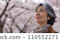 Senior woman walking in the cherry blossoms 2 110552271