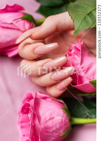 Female hands with pink nail design  hold pink roses 110552373