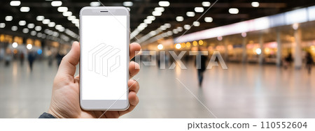 hand holding a mock-up smartphone with a blank screen, set against the dynamic backdrop of an airport interior. This versatile visual is perfect for presenting mobile app designs Generative AI 110552604