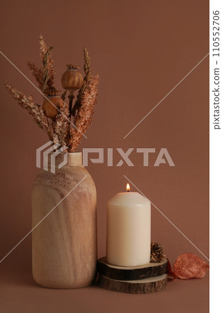 Autumn dried flowers in the vase and vanilla candle on brown background. Warm aesthetic autumn composition. Home comfort, spa, relax and wellness concept 110552706