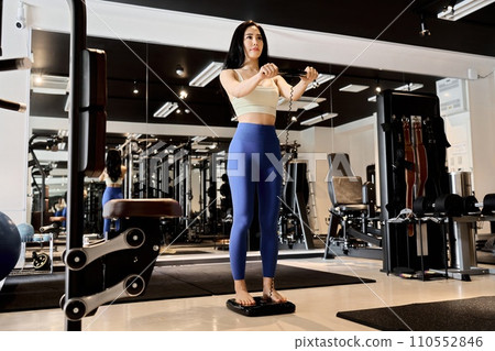 一位女士在健身房使用體脂秤 一位女士在健身房使用體脂秤 110552846