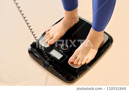 一位女士在健身房使用體脂秤 一位女士在健身房使用體脂秤 110552848
