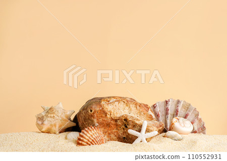 Seashells with starfish and stone on sand, beige background. Podium for cosmetics products. Sea summer vacation card with space for the text 110552931
