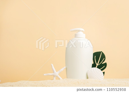 Summer Skin Care Cosmetic white bottle with shells and monstera leaf on the sand, beige background. sea natural cream package mockup 110552938